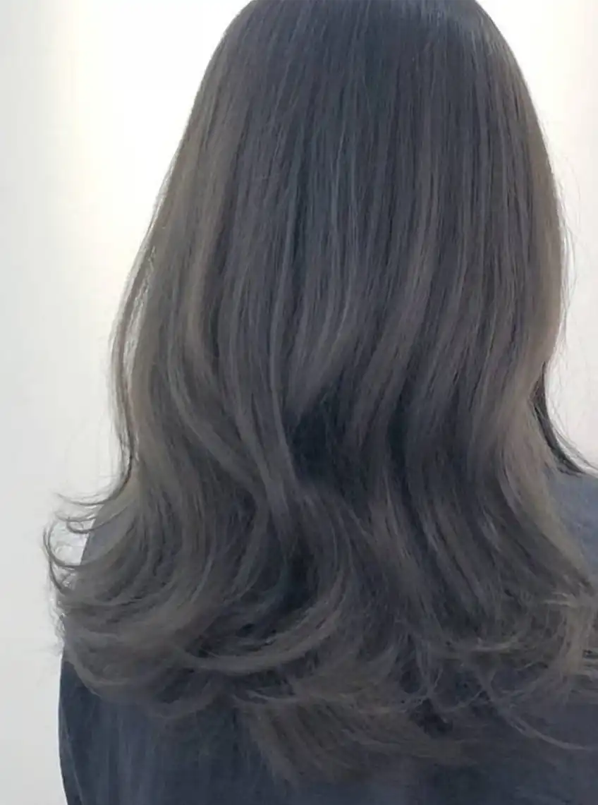 Lange Wellenfrisur mit aschblauer Haarfarbe